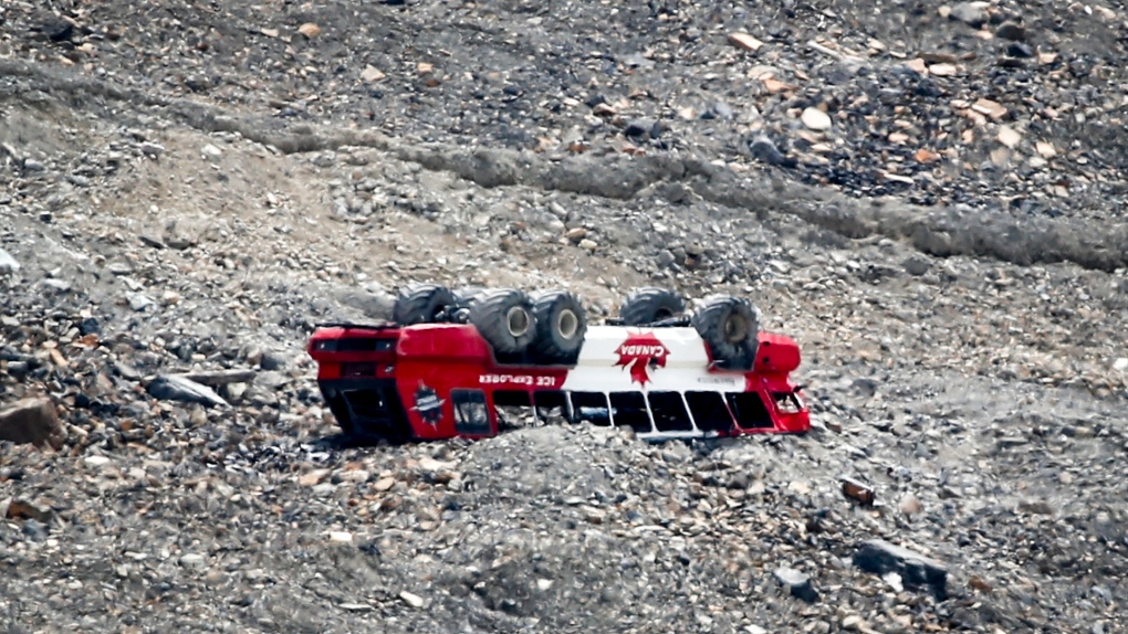 A rolled-over tour bus rests where it fell on the Columbia Icefield near Jasper, Alta., Sunday, July 19, 2020. RCMP say three passengers were killed when the sightseeing bus rolled over at the icefields. THE CANADIAN PRESS/Jeff McIntosh