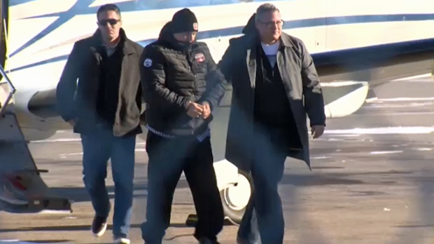 Stephane Parent is escorted from a plane by RCMP after landing in Calgary to face a second-degree murder charge in the death of Adrienne McColl