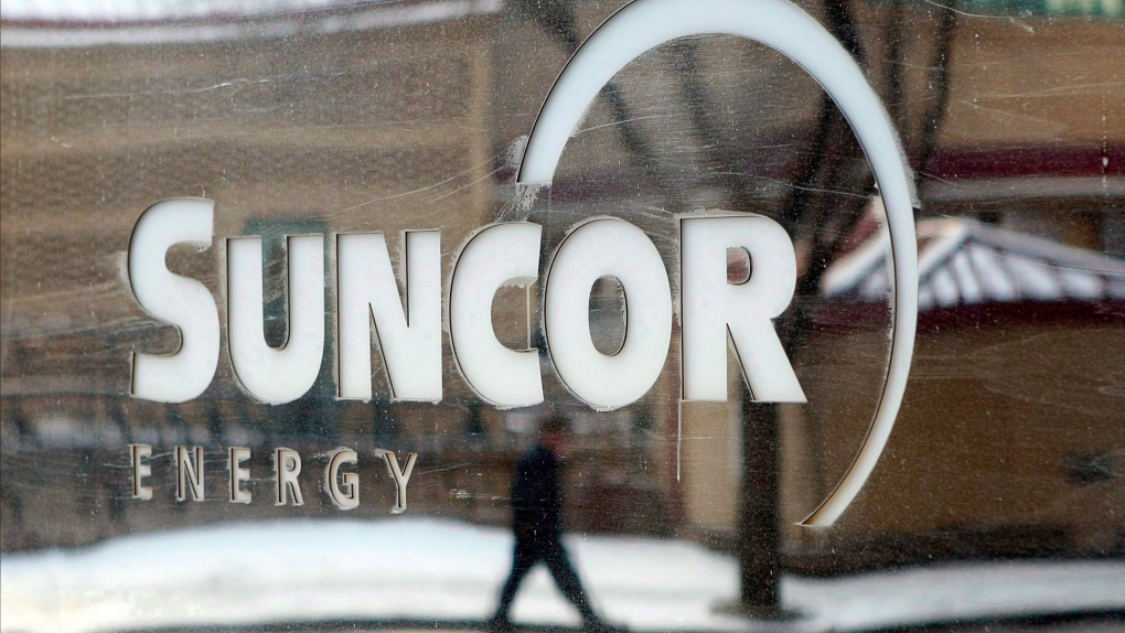  A pedestrian is reflected in a Suncor Energy sign in Calgary, Monday, Feb. 1, 2010. THE CANADIAN PRESS/Jeff McIntosh 