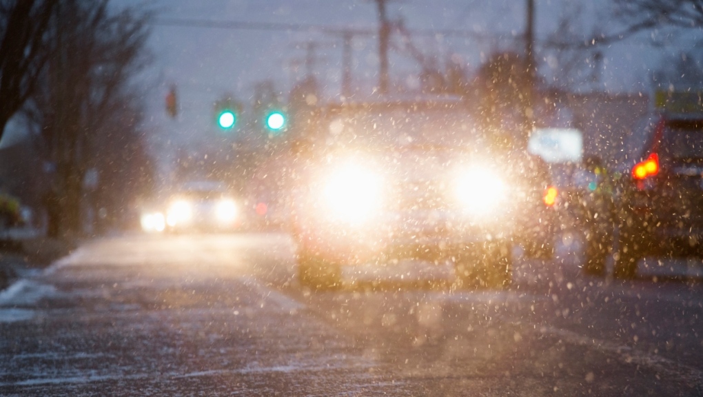 A stock photo of a car driving on snowy street at night. (Getty Images)
