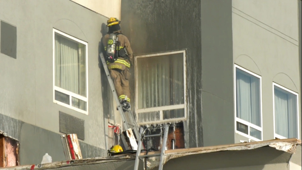 Calgary firefighters used saws and axes to cut into the exterior wall of a northeast hotel after flames were reported by a roofing company working there. 