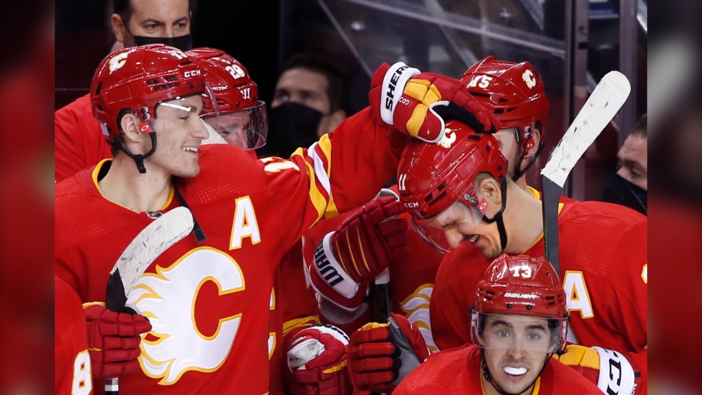 Calgary Flames player Mikael Backlund, right, is congratulated by Matthew Tkachuk after his winning shootout goal against the Pittsburgh Penguins in NHL action in Calgary on Nov. 29, 2021. (THE CANADIAN PRESS/Larry MacDougal)