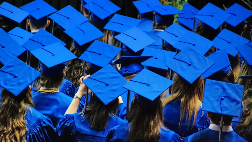 A celebration of graduation with a sea of blue graduation caps and robes. (Getty Images)