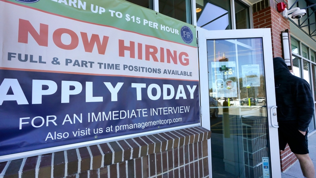 A man walks into a restaurant displaying a "Now Hiring" sign, Thursday, March 4, 2021, in Salem, N.H. (AP Photo/Elise Amendola) 