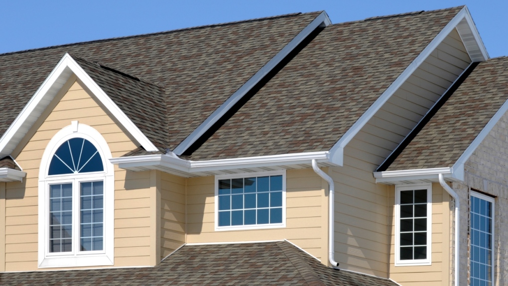 A stock photo of a house with an asphalt shingle roof and vinyl siding. (Getty Images)