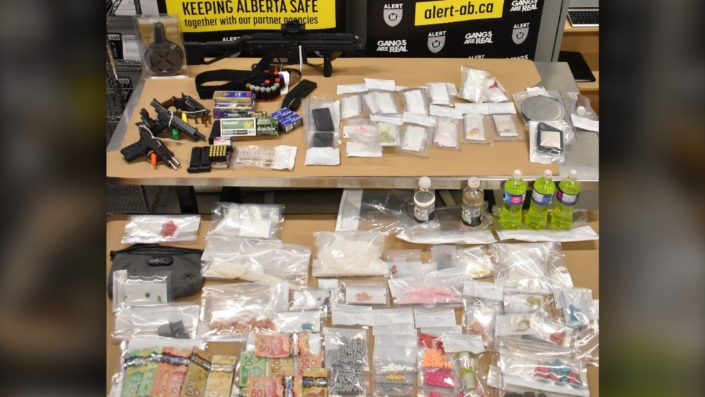 Guns, drugs and cash seized during the search of two homes and two vehicles in Olds and Sundre on Nov. 24. (ALERT)