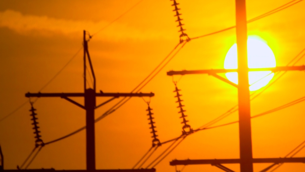 A stock photo shows the sun rising behind power lines. (Getty Images) 