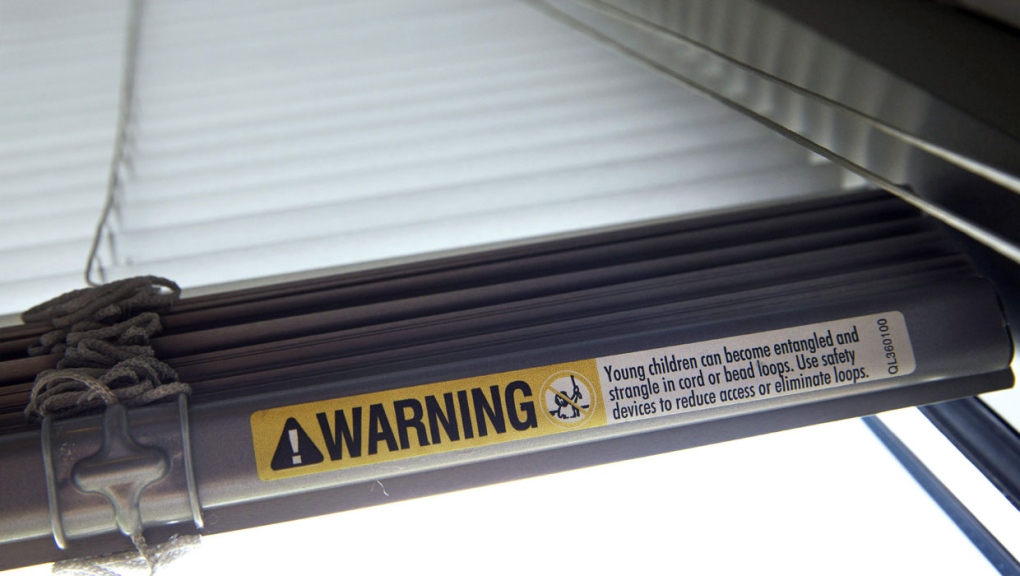 This Wednesday, May 6, 2015 file photo shows a warning label of strangulation risks from mini blind cords in Washington. Starting May 1, Health Canada will be enforcing new rules on corded window blinds being sold by Canadian retailers. (AP Photo/Jacquelyn Martin)