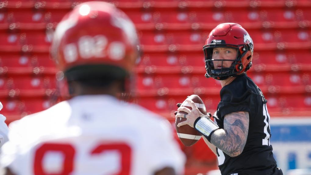 Calgary Stampeders quarterback Bo Levi Mitchell, right, looks to Malik Henry during opening day of the CFL team's training camp in Calgary, Sunday, May 15, 2022 (The Canadian Press/Jeff McIntosh).