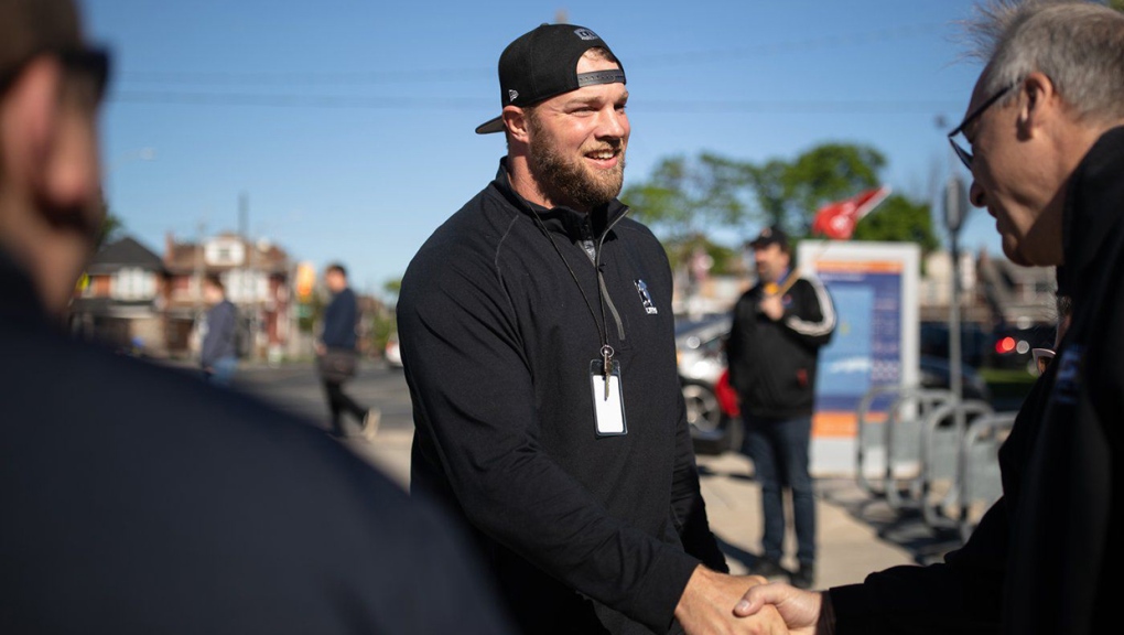 Hamilton Tiger-Cats offensive lineman Chris Van Zeyl shakes hands with local labour union representatives during a Canadian Football League Players’ Association (CFLPA) demonstrating outside Tim Hortons Field in Hamilton, Ont., on Tuesday, May 17, 2022. On Sunday afternoon, CFLPA members were locked out of club facilities by team owners in seven of nine cities. THE CANADIAN PRESS/Nick Iwanyshyn