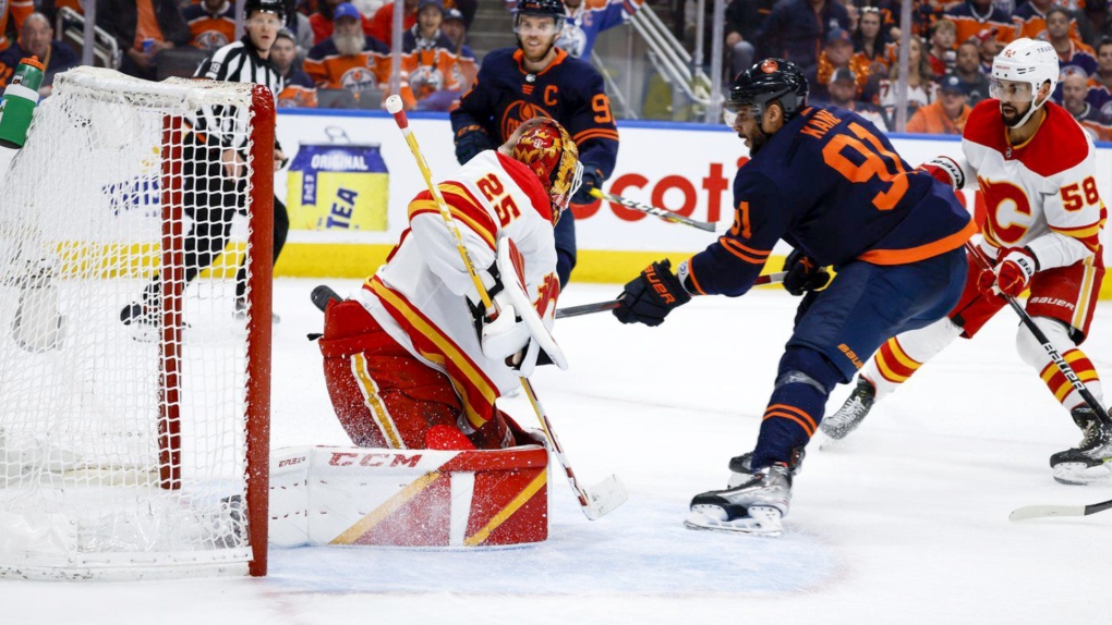Calgary Flames goalie Jacob Markstrom, left, lets in a goal from Edmonton Oilers winger Evander Kane during second period NHL second round playoff hockey action in Edmonton, Sunday, May 22, 2022. Kane scored a natural hat trick during an electric six-minute span and captain Connor McDavid provided more magic with three assists in another dominant performance as the Edmonton Oilers downed the Calgary Flames 4-1 on Sunday to take a 2-1 lead in their second-round playoff series. Jeff McIntosh/The Canadian Press