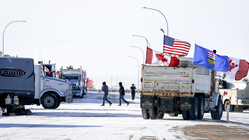 The last truck blocking the southbound lane moves off after a breakthrough to resolve the impasse at a protest blockade at the United States border in Coutts, Alta., Wednesday, Feb. 2, 2022. Trucks and other vehicles have begun clearing two lanes -- one going north and one going south. THE CANADIAN PRESS/Jeff McIntosh