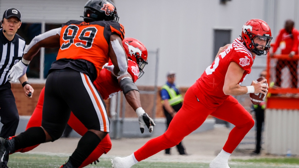 B.C. Lions' Miles Fox, left, chases Calgary Stampeders' quarterback Tommy Stevens during second half CFL pre-season football action in Calgary, Saturday, May 28, 2022 (The Canadian Press/Jeff McIntosh).