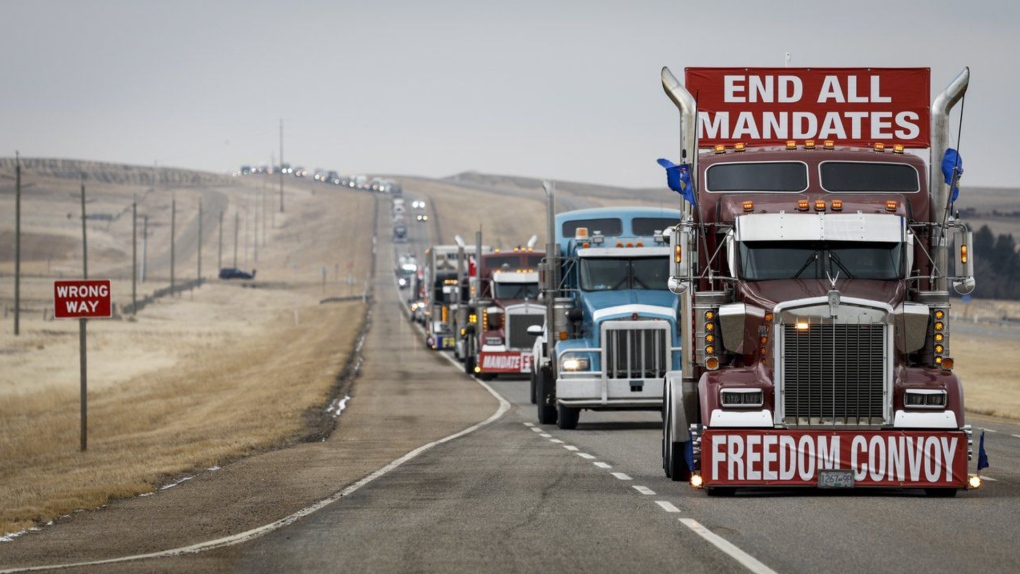 Demonstrators against COVID-19 vaccine mandates and other restrictions leave in a truck convoy after blocking the highway at the busy U.S. border crossing near Coutts, Alta., on Tuesday, Feb. 15, 2022.(THE CANADIAN PRESS/Jeff McIntosh)