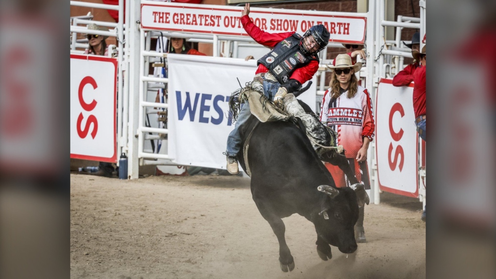 Dakota Buttar, of Eatonia, Sask., rides Lil Hootch to a tie during bull riding rodeo finals action at the Calgary Stampede in Calgary, Alta., Sunday, July 17, 2022. (THE CANADIAN PRESS/Jeff McIntosh)