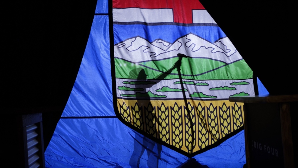 A campaign worker steams the wrinkles from a large Alberta flag at a United Conservative Party event in Calgary on April 16, 2019. (THE CANADIAN PRESS/Jeff McIntosh)