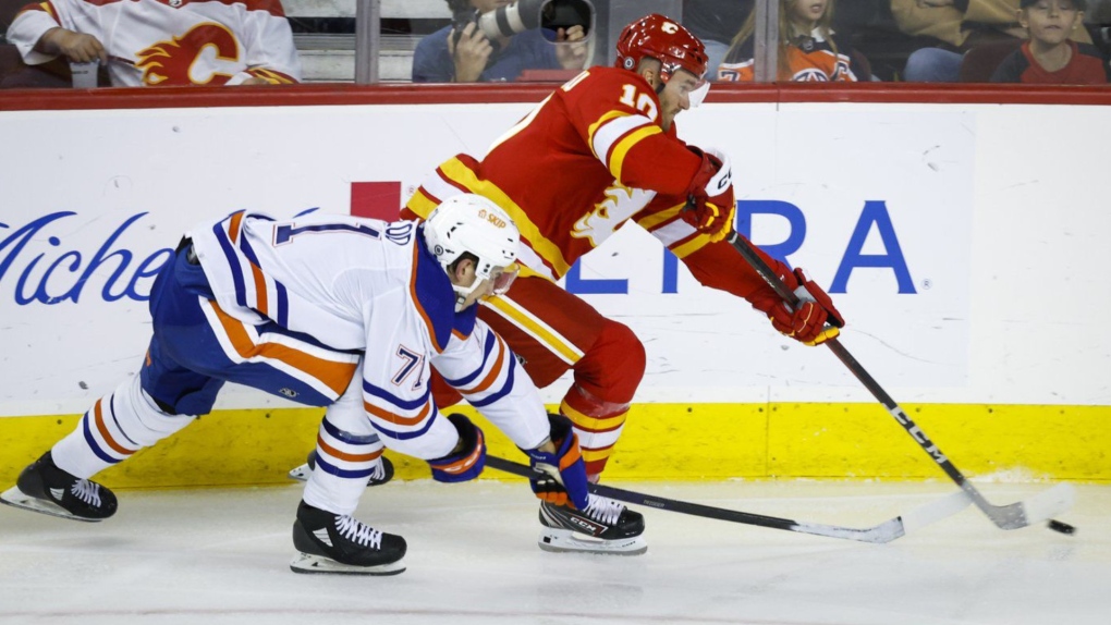 Edmonton Oilers forward Ryan Mcleod, left, checks Calgary Flames forward Jonathan Huberdeau during second period NHL pre-season hockey action in Calgary on Sept. 28, 2022. (THE CANADIAN PRESS/Jeff McIntosh)