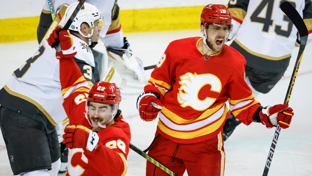 Vegas Golden Knights defenceman Brayden McNabb, left, looks on as Calgary Flames forward A.J. Greer, right, celebrates his goal during third period NHL hockey action in Calgary, Alta., Monday, Nov. 27, 2023. THE CANADIAN PRESS/Jeff McIntosh