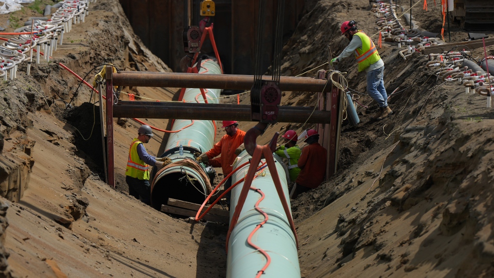 Workers lay pipe during construction of the Trans Mountain pipeline expansion on farmland in Abbotsford, B.C., on Wednesday, May 3, 2023. THE CANADIAN PRESS/Darryl Dyck