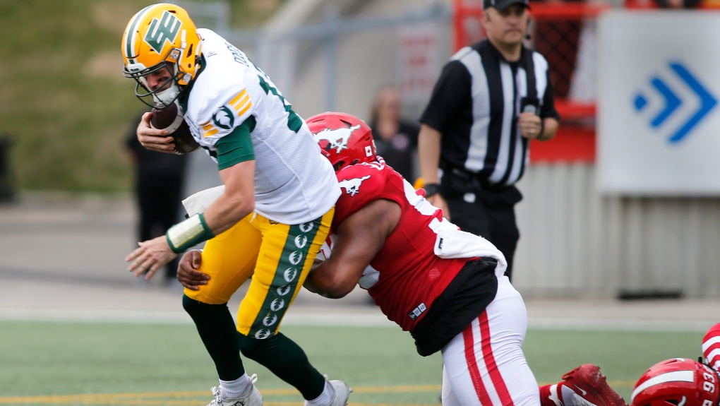Edmonton Elks quarterback Jarret Doege is sacked by Calgary Stampeders defensive lineman T.J. Rayam during first half CFL exhibition football action in Calgary, Monday, May 22, 2023. (THE CANADIAN PRESS/Larry MacDougal)