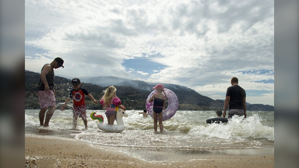 Beach goers play in the waves of Skaha Lake in Penticton, B.C. Friday, Aug. 21, 2020;Police in British Columbia say an Alberta teen is dead after a Jet Ski collision on Skaha Lake.THE CANADIAN PRESS/Jonathan Hayward