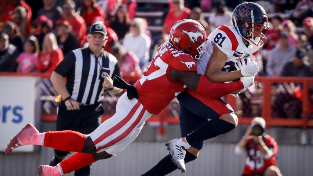 Montreal Alouettes receiver Austin Mack, right, is tackled by Calgary Stampeders linebacker Micah Awe during second half CFL football action in Calgary, Saturday, Sept. 23, 2023. (THE CANADIAN PRESS/Jeff McIntosh)