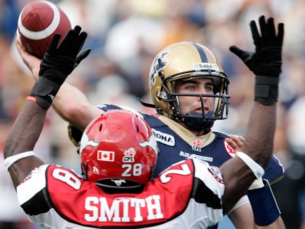 Winnipeg Blue Bombers' Ryan Dinwiddie (4) throws under pressure from Calgary Stampeders' Brandon Smith (28) during the first half of their CFL football game in Winnipeg Thursday, July 24, 2008. THE CANADIAN PRESS/John Woods